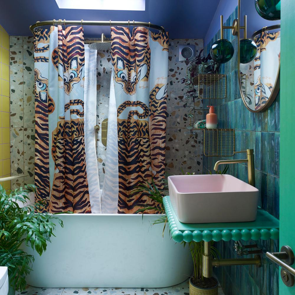 Bathroom design featuring a playful tiger stripe shower curtain and vibrant colors