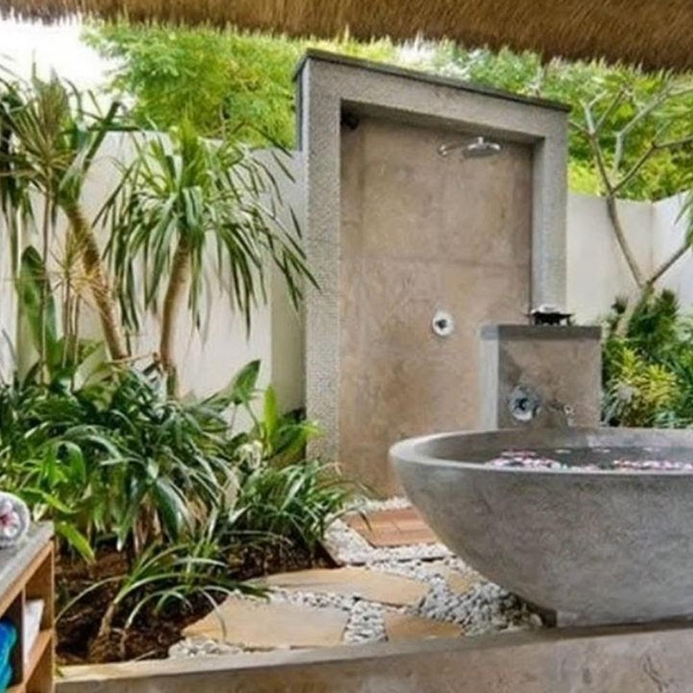 Outdoor-inspired bathroom with lush greenery and calming stone shower