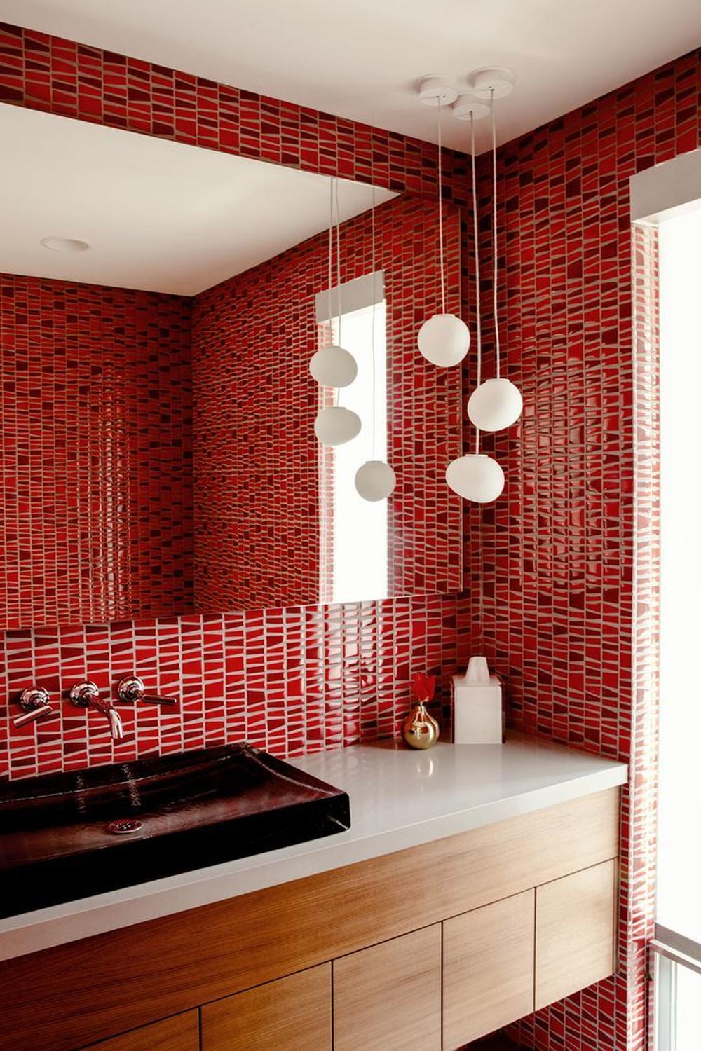 Baño luminoso con azulejos rojos y elementos naturales
