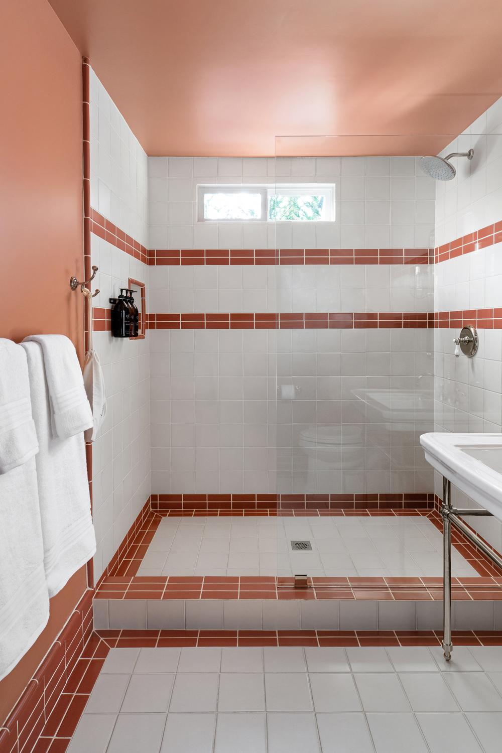 Baño moderno en tonos cálidos con azulejos rojos