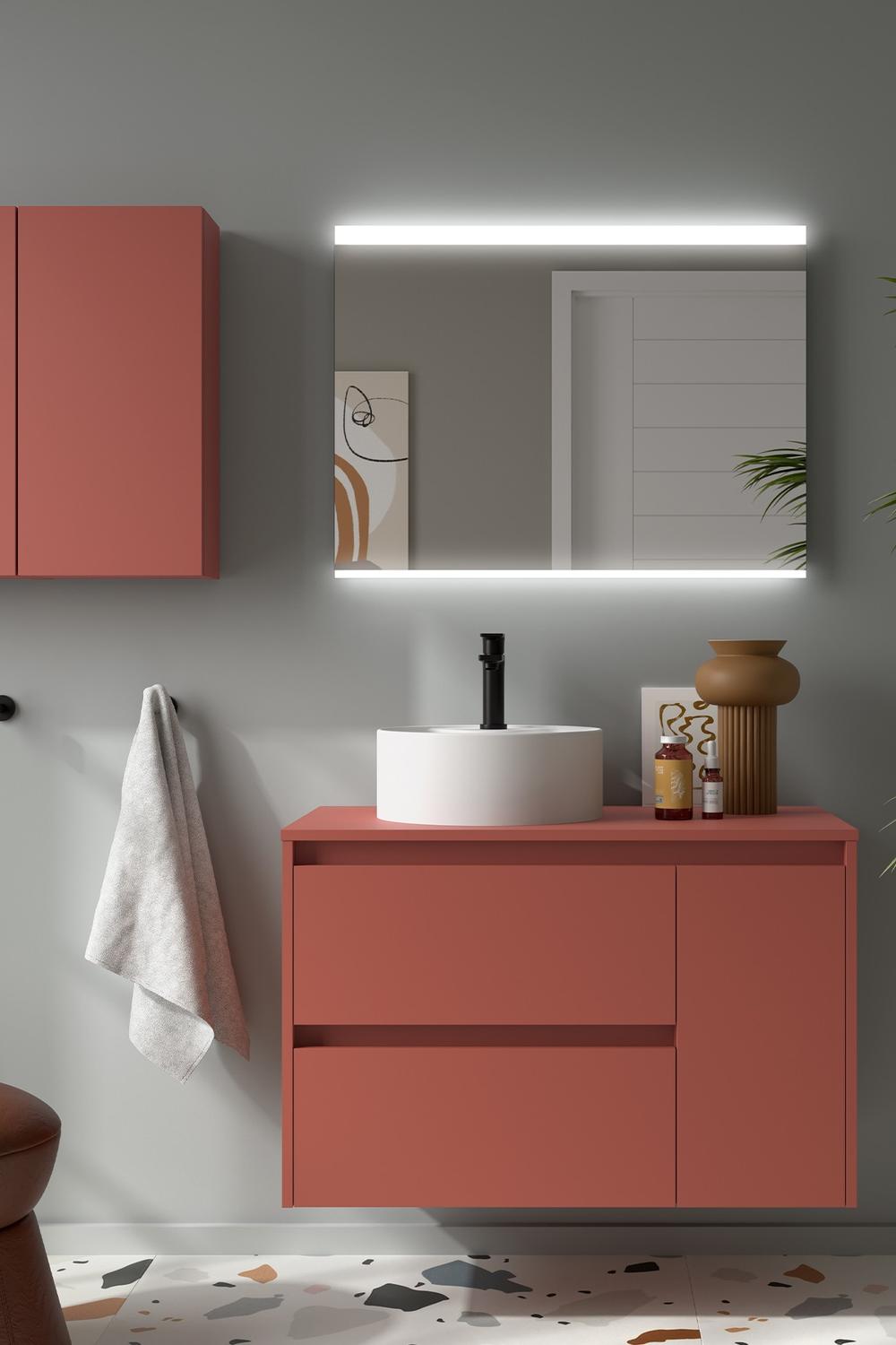 A bold red vanity with a round white sink and elegant overhead cabinets.