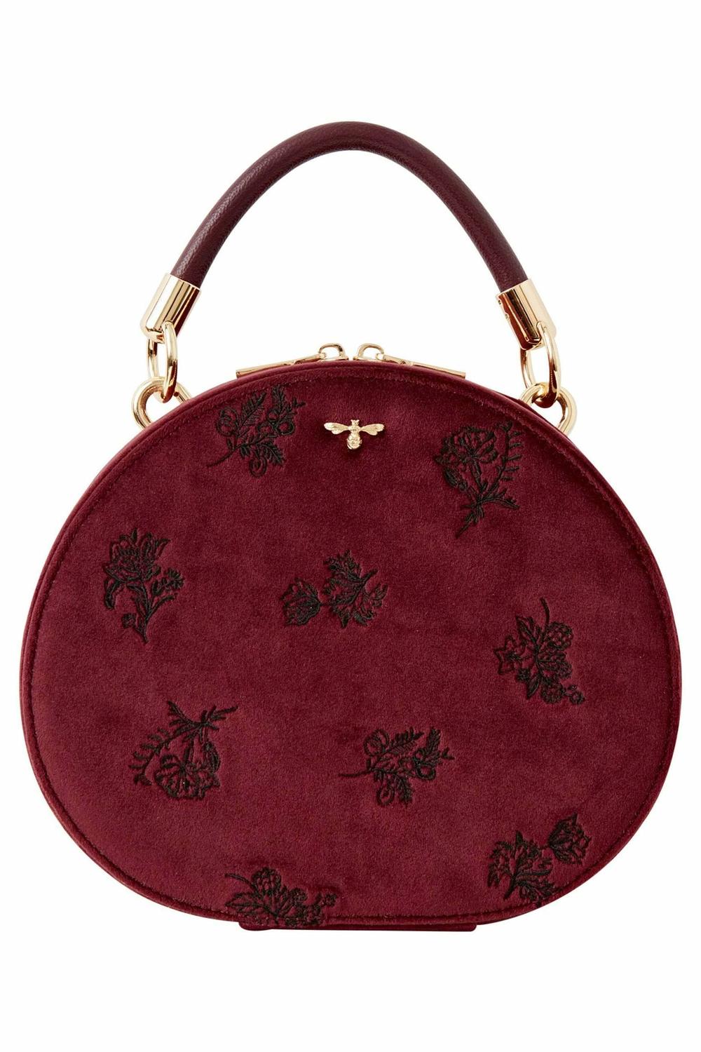 A contemporary round burgundy vanity bag, highlighting its elegant design.