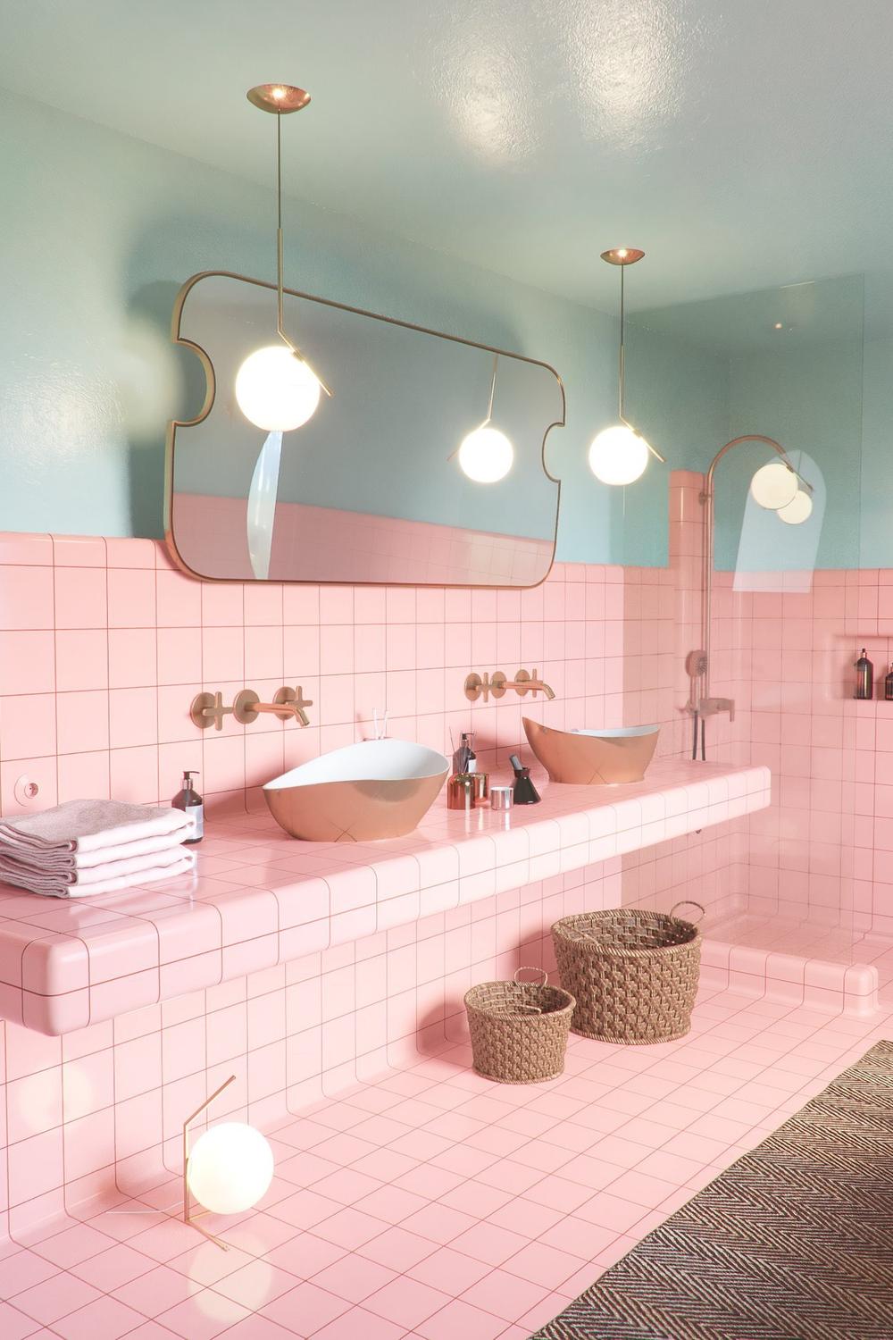 Modern retro bathroom with mint green walls and pastel pink tiles.