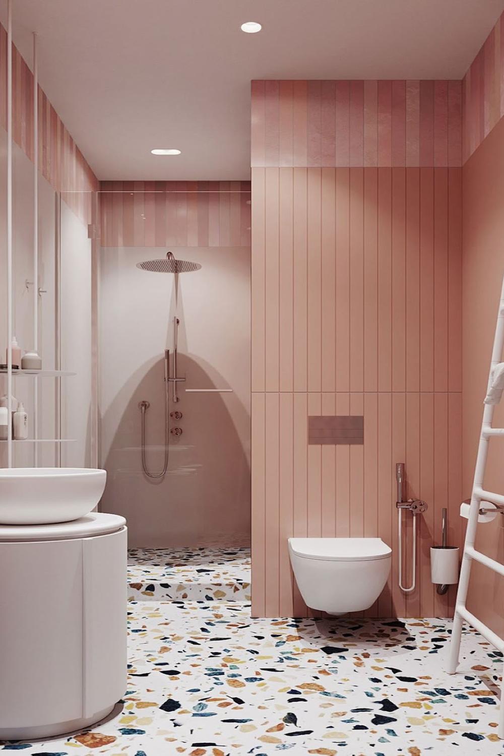 Stylish retro bathroom with vibrant terrazzo floor pattern and round white basin.
