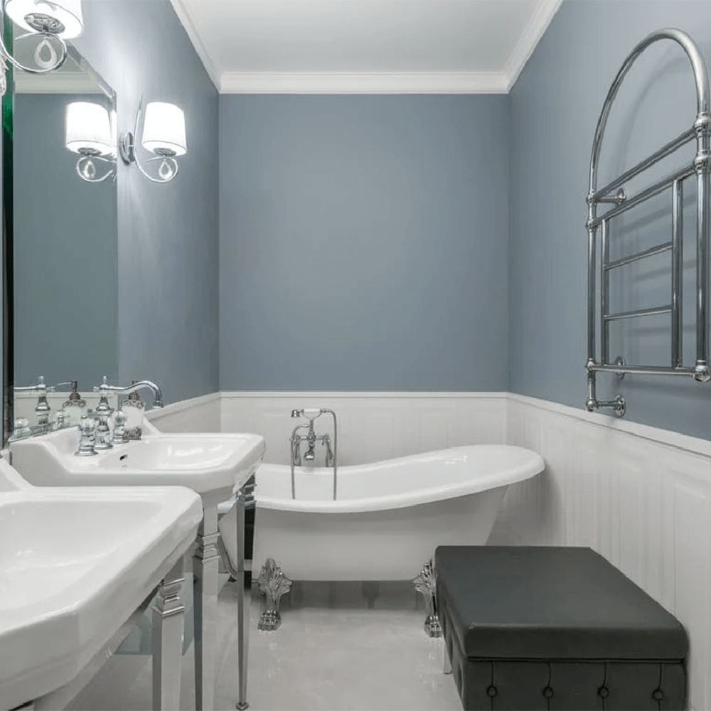 Elegantly styled retro bathroom featuring soft blue walls and freestanding bathtub.