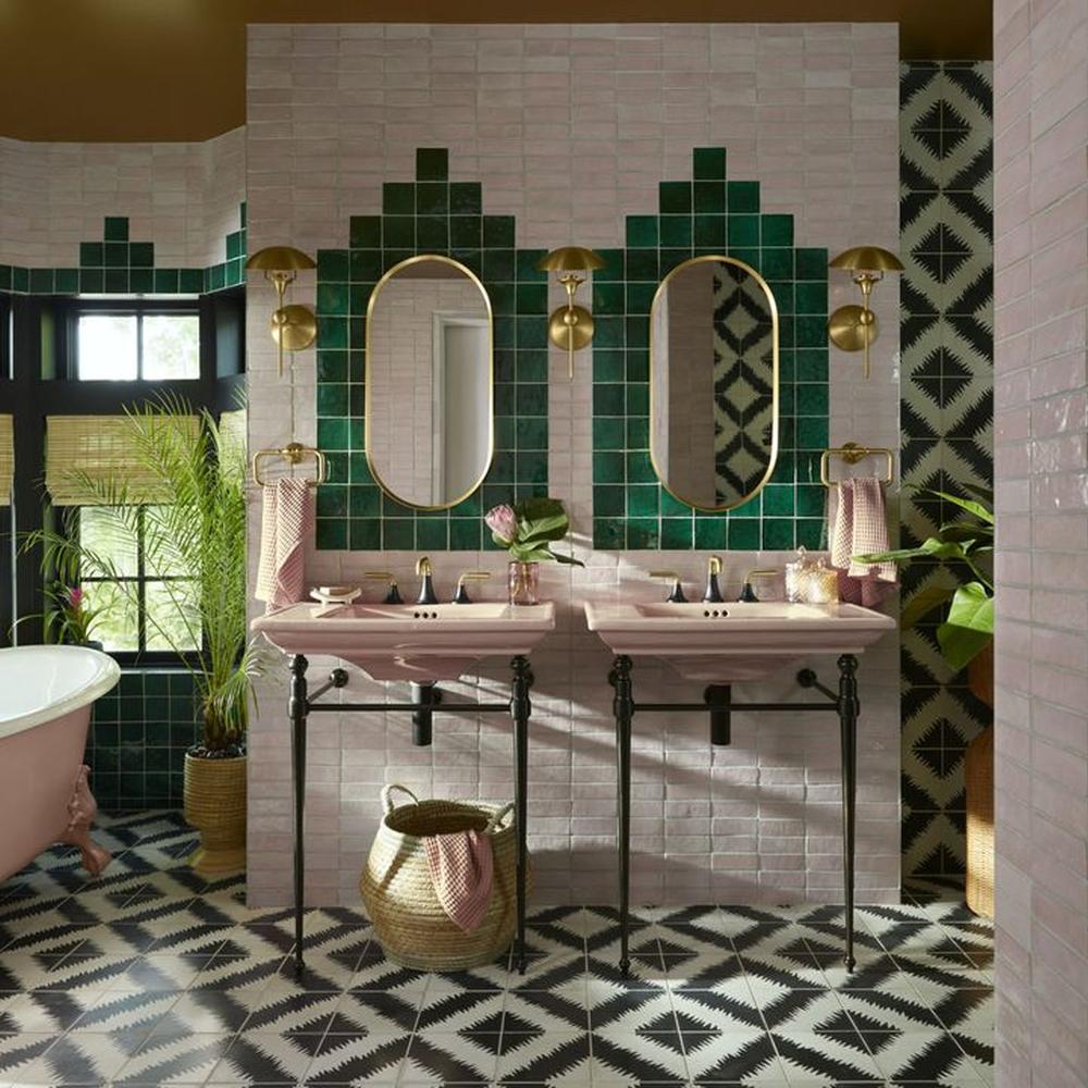 Retro bathroom featuring dual sinks with pink accents and bold tile designs.