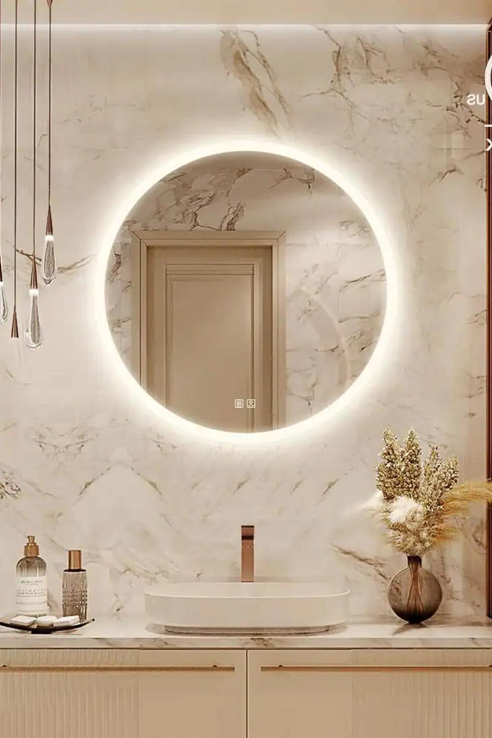 Chic round mirror accented by luxurious marble walls and minimalist sink area.