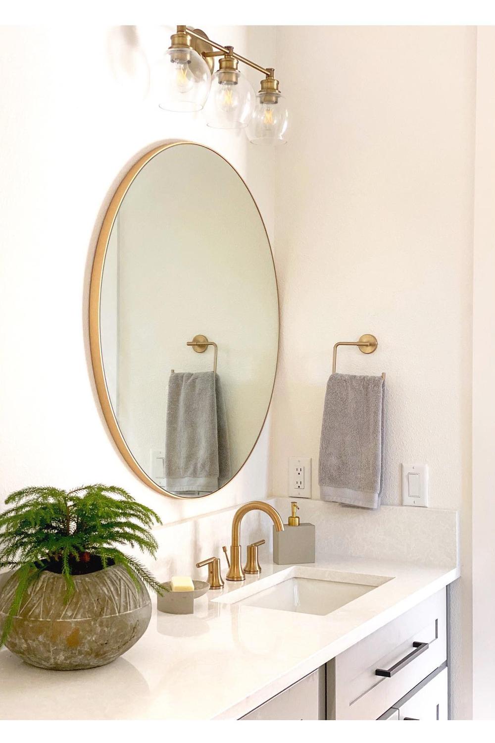 Double sink vanity with graciously framed round mirrors enhancing the modern bathroom.