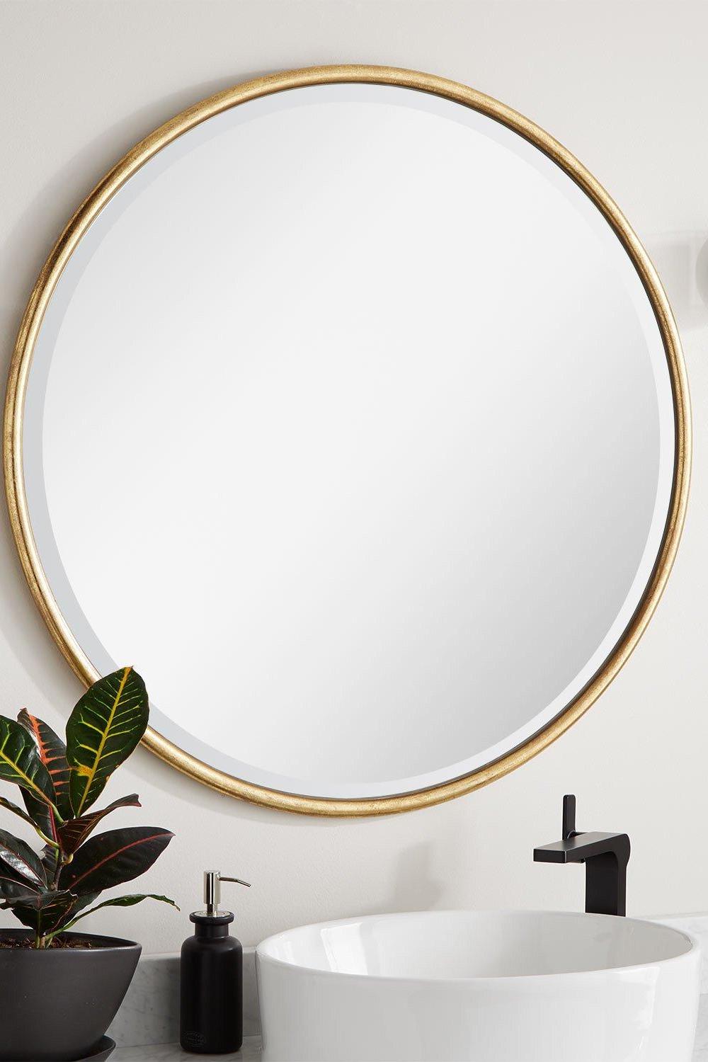 Round mirror highlighted against a textured wall adding depth to a modern bathroom.