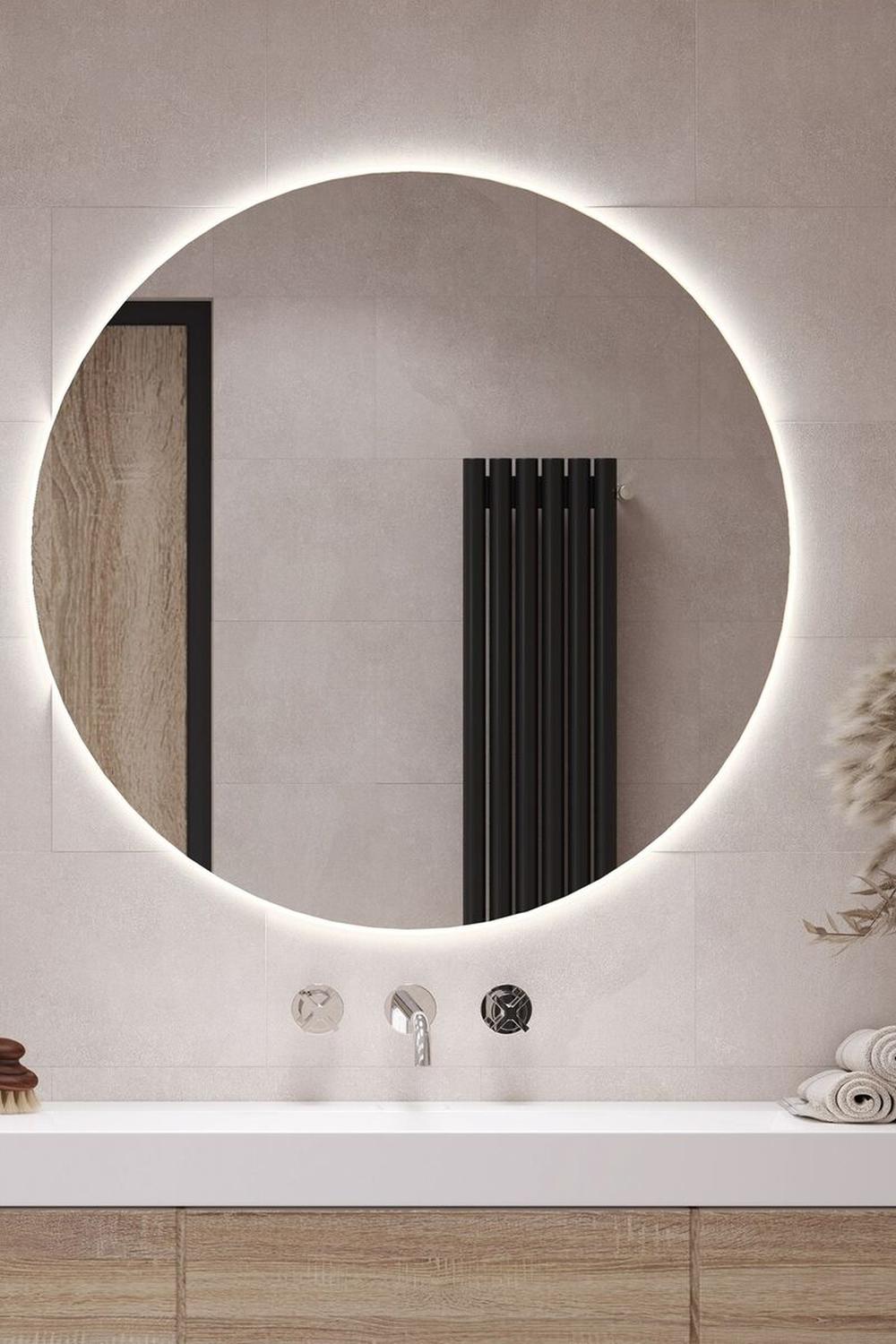 Modern round mirror surrounded by tasteful warm metallic accents and elegant textures.