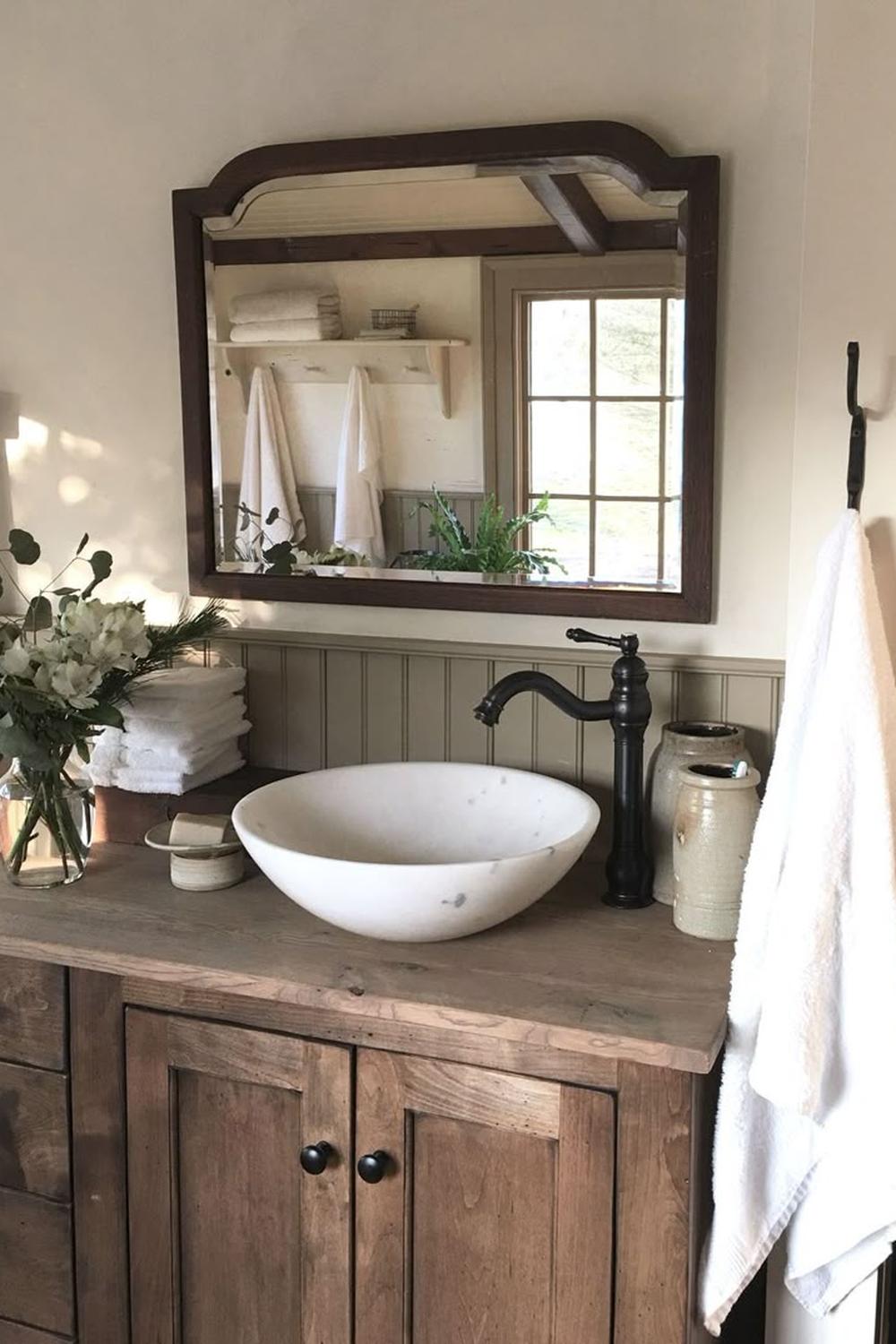 Rustic farmhouse bathroom featuring a sturdy natural wood vanity with a stone basin.