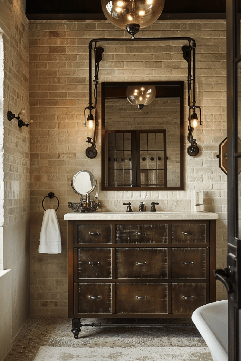 A beautifully designed rustic industrial bathroom with exposed brick walls, dark-stained wood vanity, and stylish lighting fixtures.