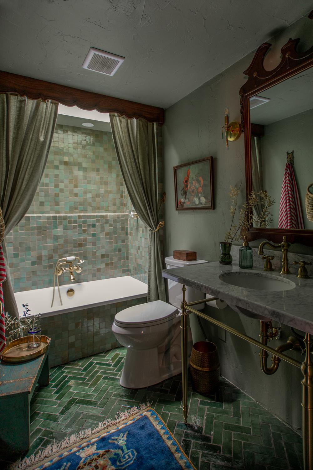 Cozy bathroom with herringbone flooring and sage green elements.