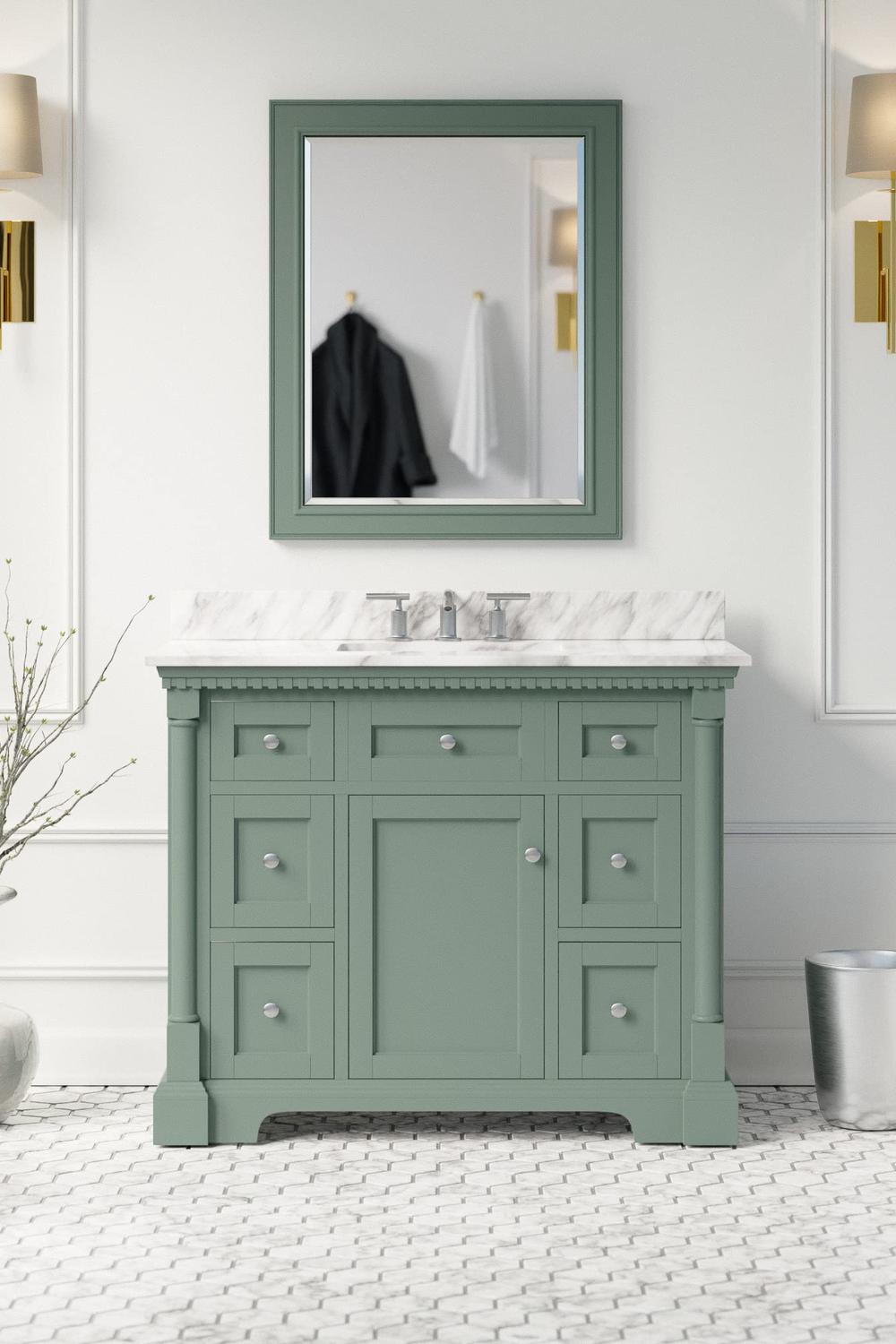 Traditional sage green vanity with white marble countertop, flanked by decorative lighting adding to the charm.