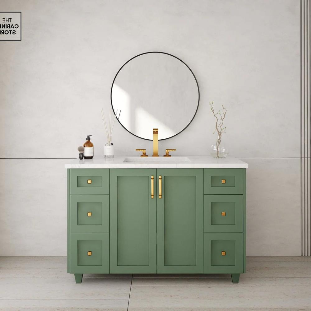 Matte finish sage green vanity with gold fixtures and a sleek marble top in a minimalist design.