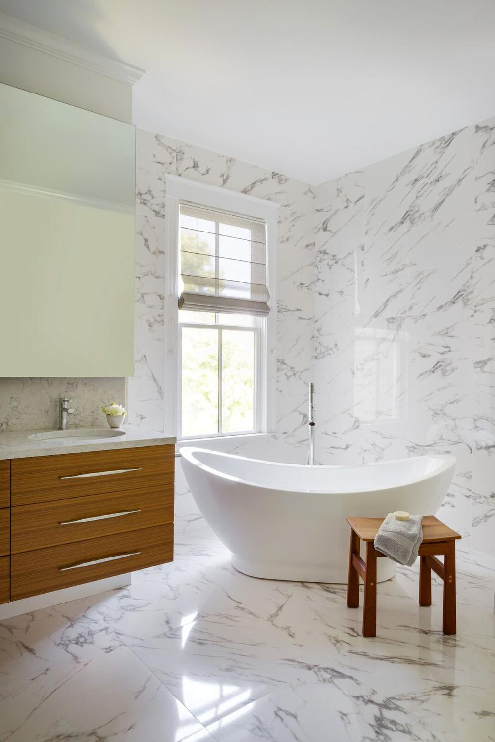 Baño escandinavo luminoso con mármol y madera