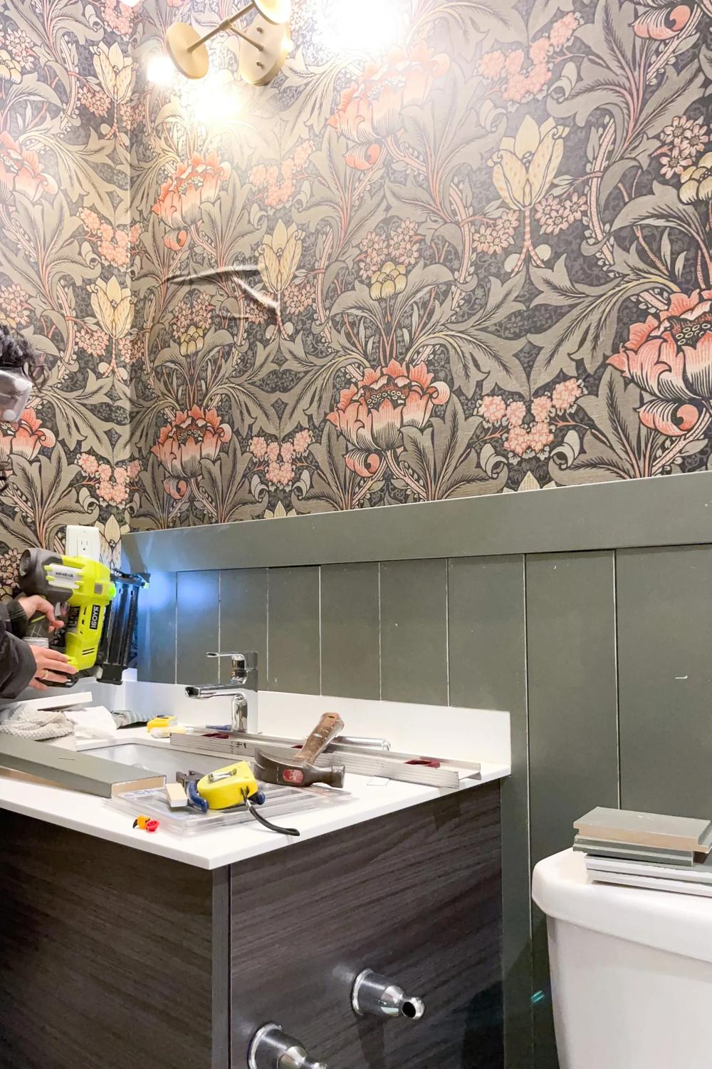 Bathroom with floral wallpaper in pastel colors and green shiplap