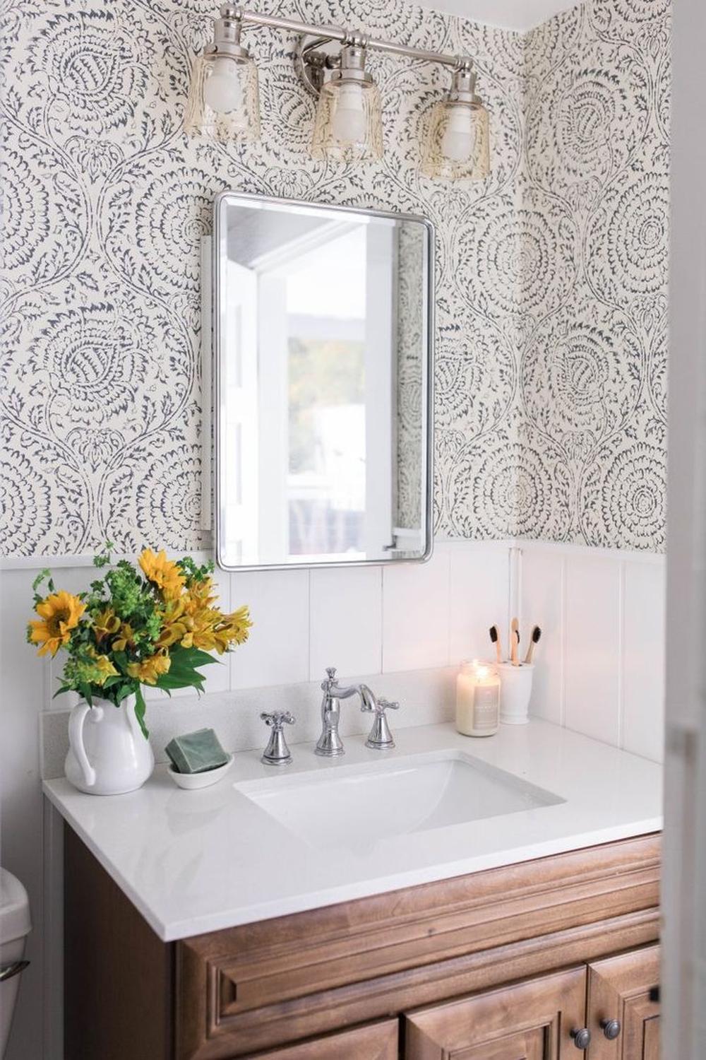 Stylish bathroom with black-and-white floral wallpaper and warm wood vanity