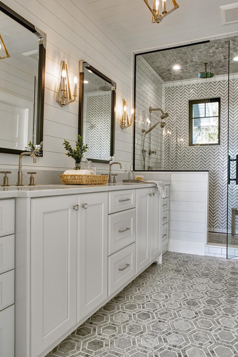 Bright bathroom with double sink vanity, white shiplap walls, and stylish wall sconces for dramatic effect.