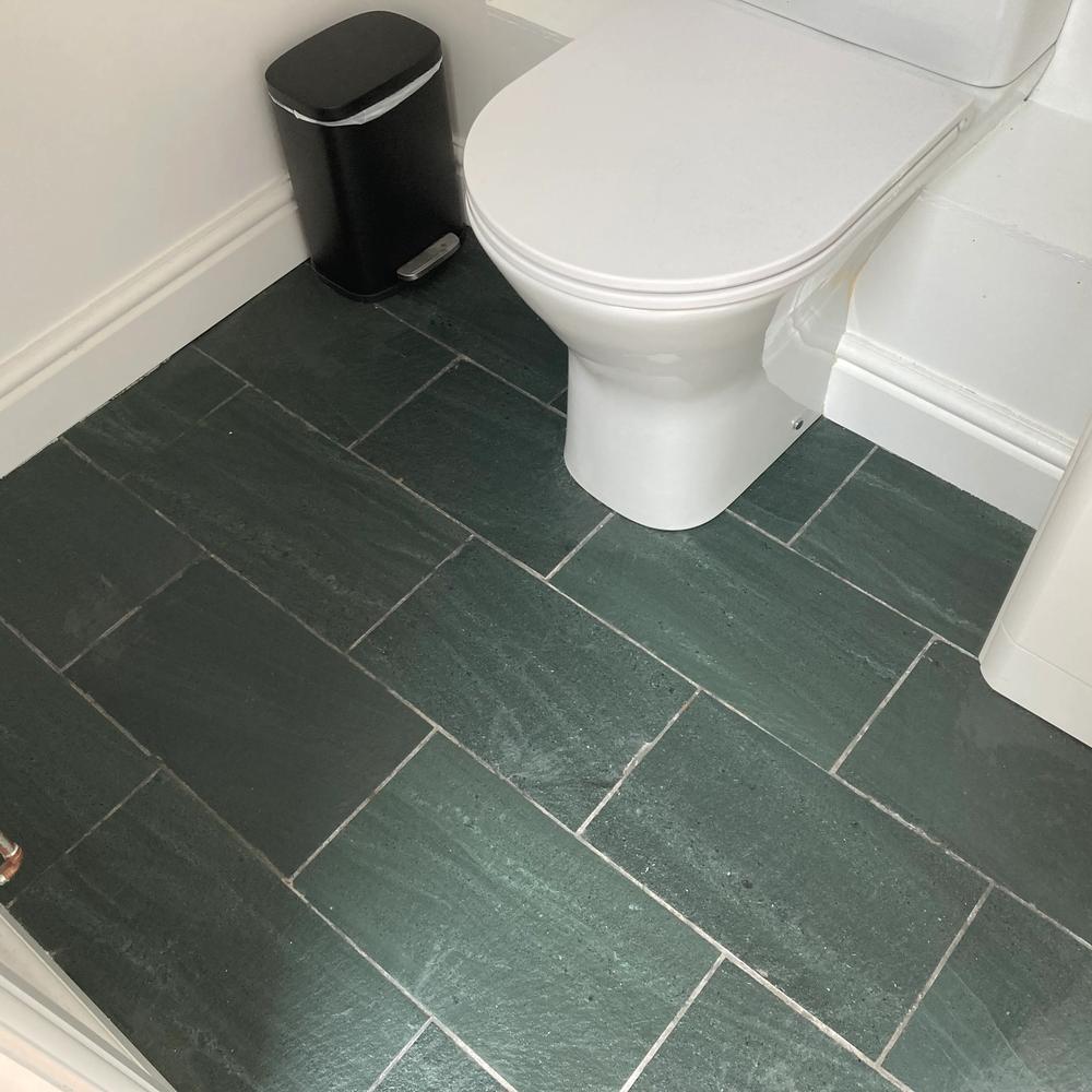 Sleek modern bathroom featuring dark green slate tile flooring