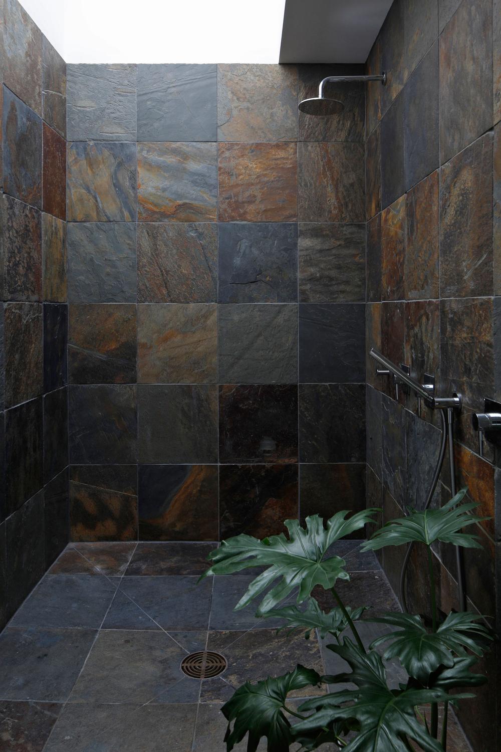 Modern shower space designed with slate tiles and natural light