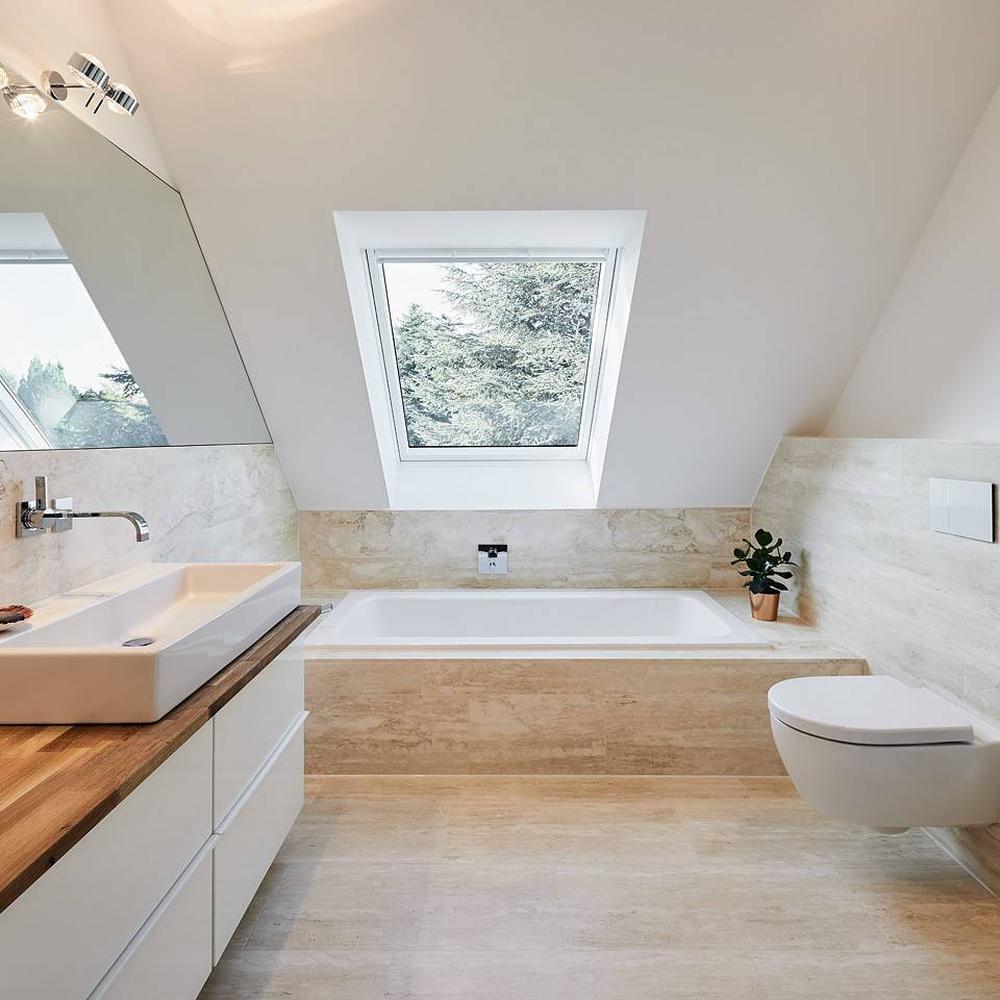 Beautifully designed bathroom with sloped ceiling and natural lighting from skylight