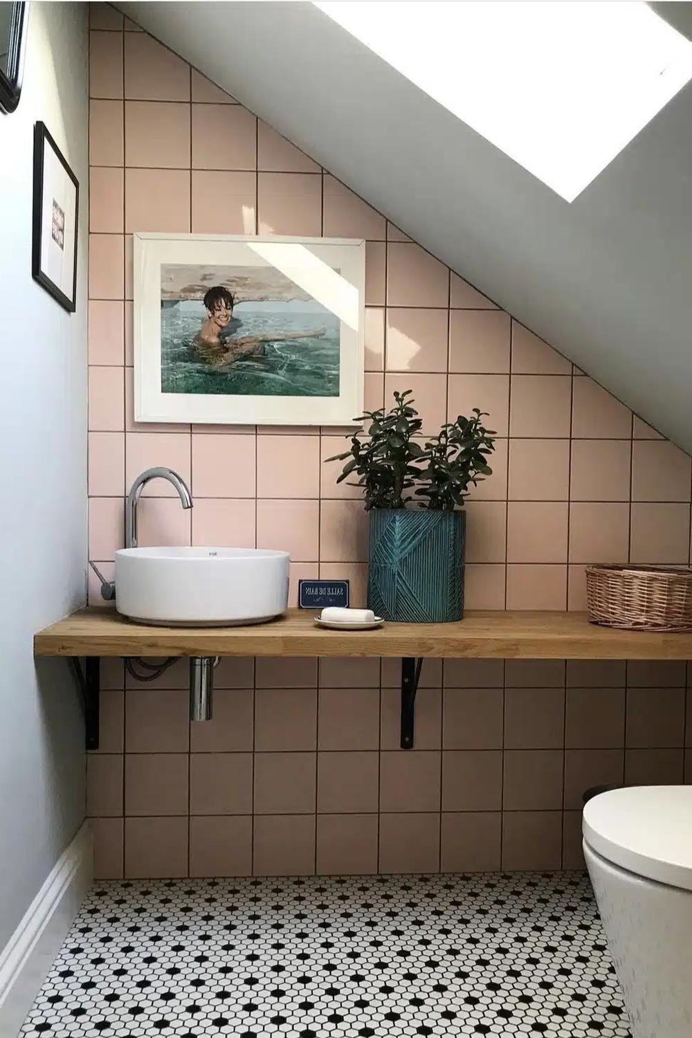 Modern bathroom featuring pink tiled walls and elegant fixtures