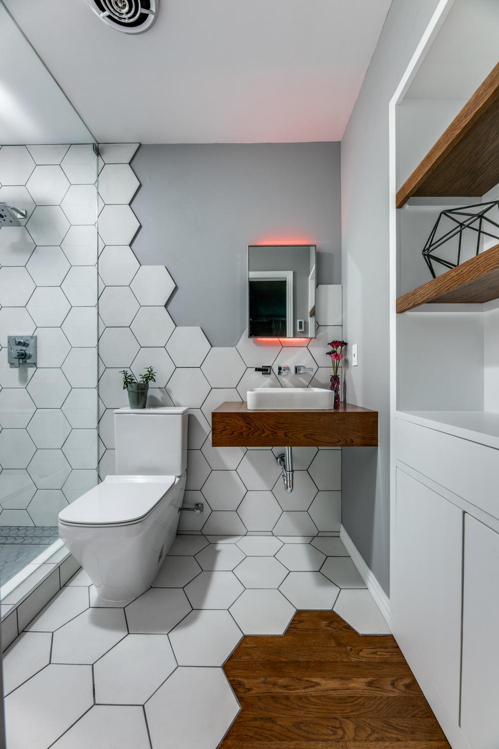 Modern small bathroom with hexagonal tiles and wooden accents