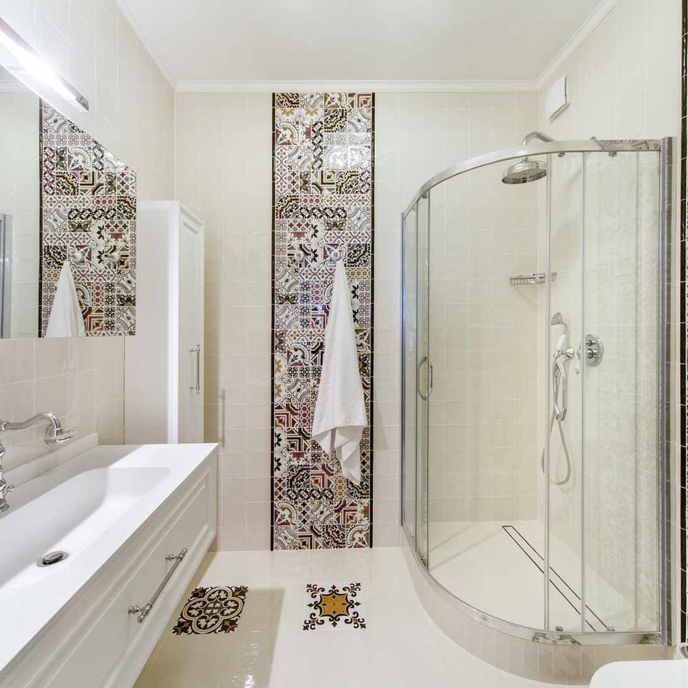 Charming small bathroom with decorative accent tiles and a modern shower