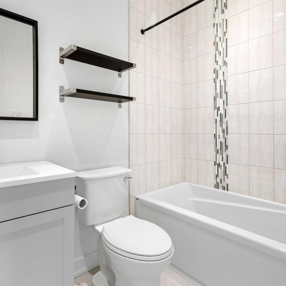 Modern small bathroom featuring a sleek white bathtub and calming color palette with chic accents.