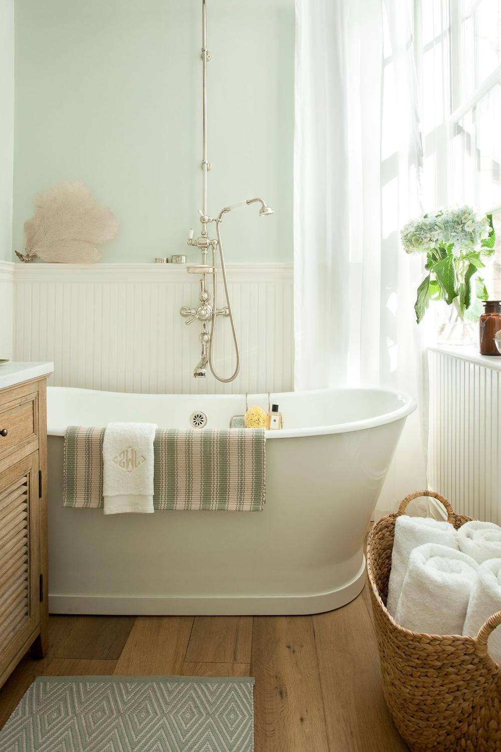 Charming small bathroom featuring a pastel-colored bathtub, playful accents, and a welcoming atmosphere.