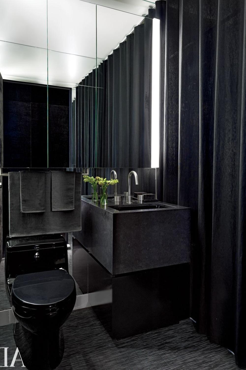 Small modern dark bathroom with ambient lighting and stylish fixtures.