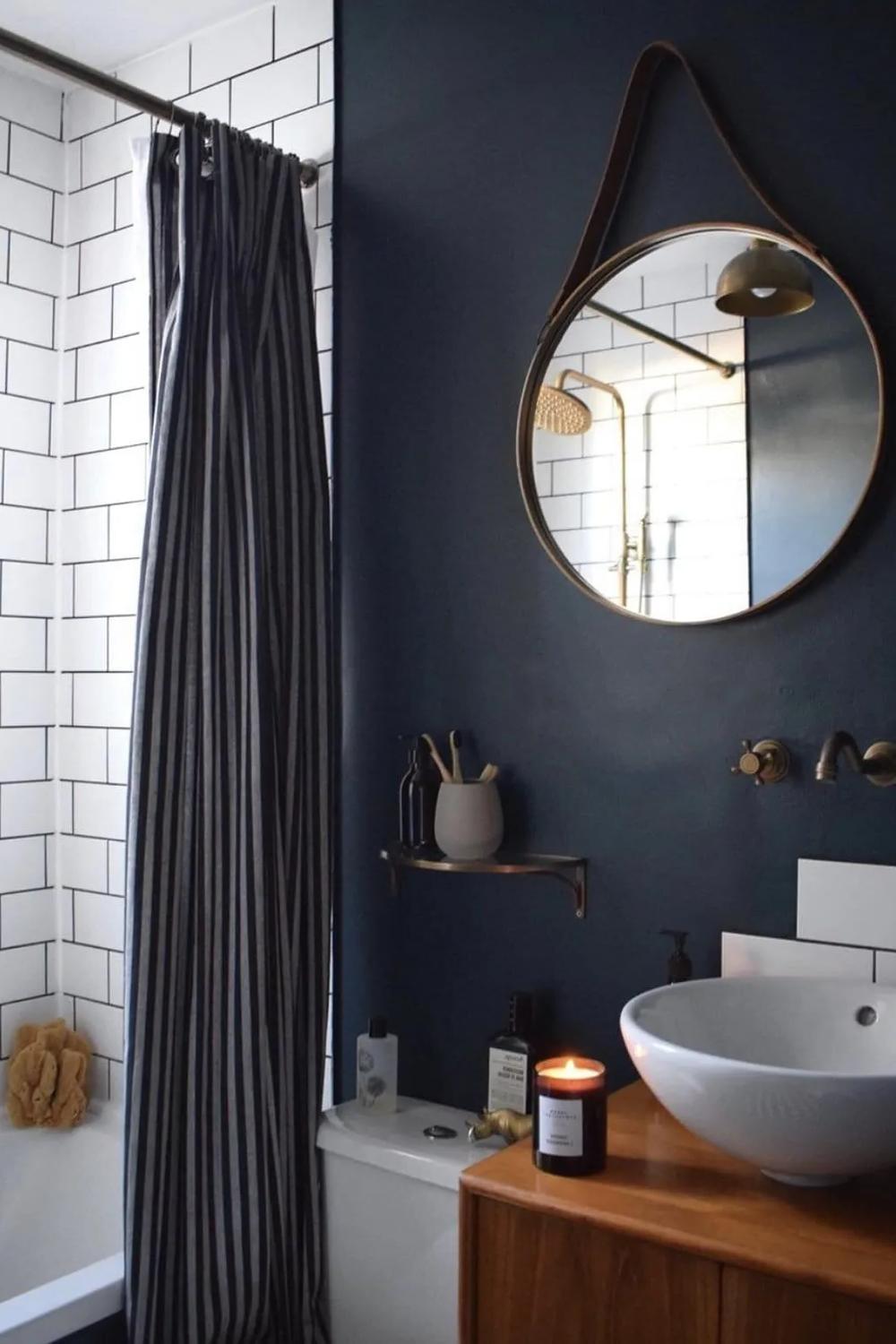 Small dark-themed bathroom with decorative mirrored elements.