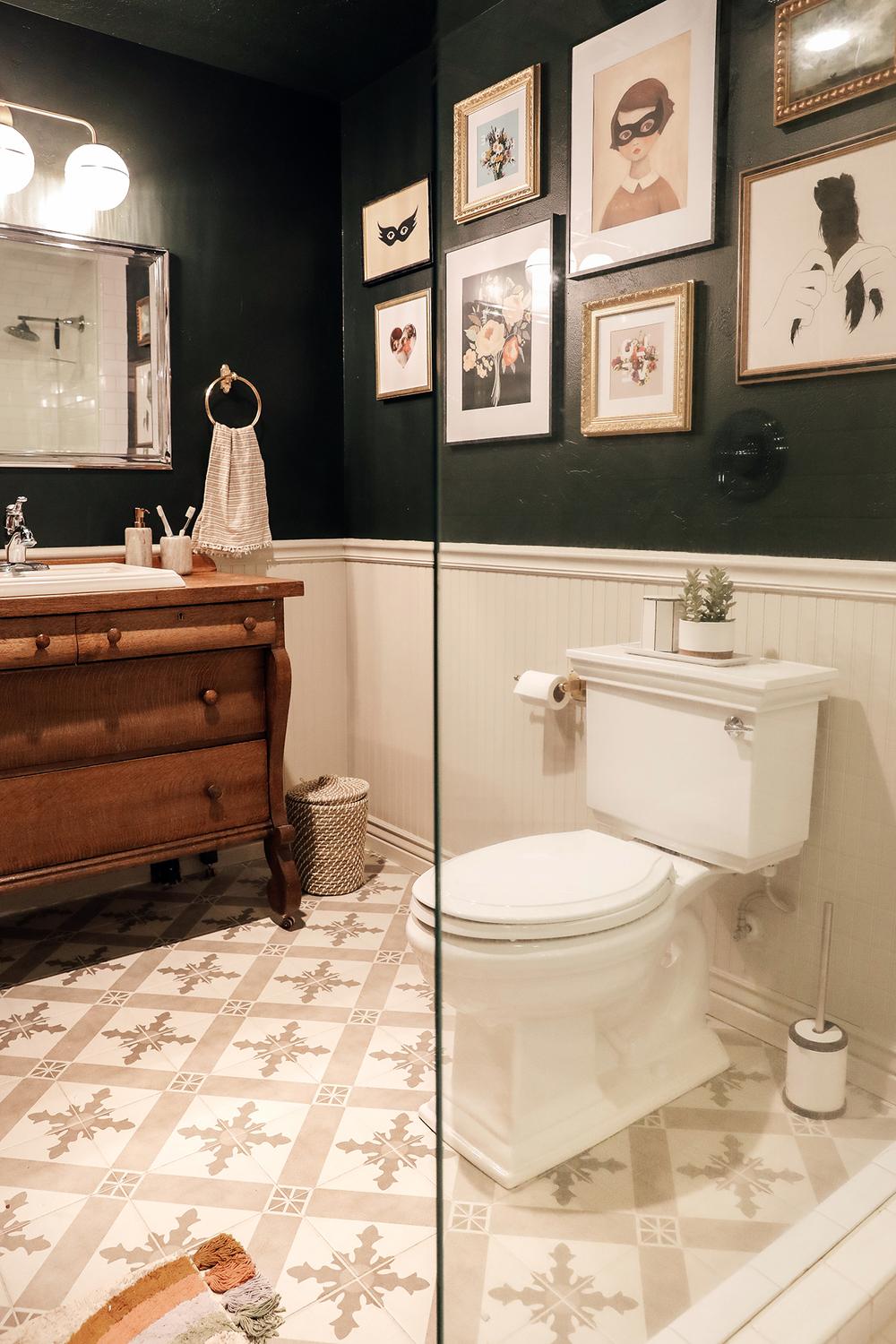 Dark bathroom with intricately patterned flooring.