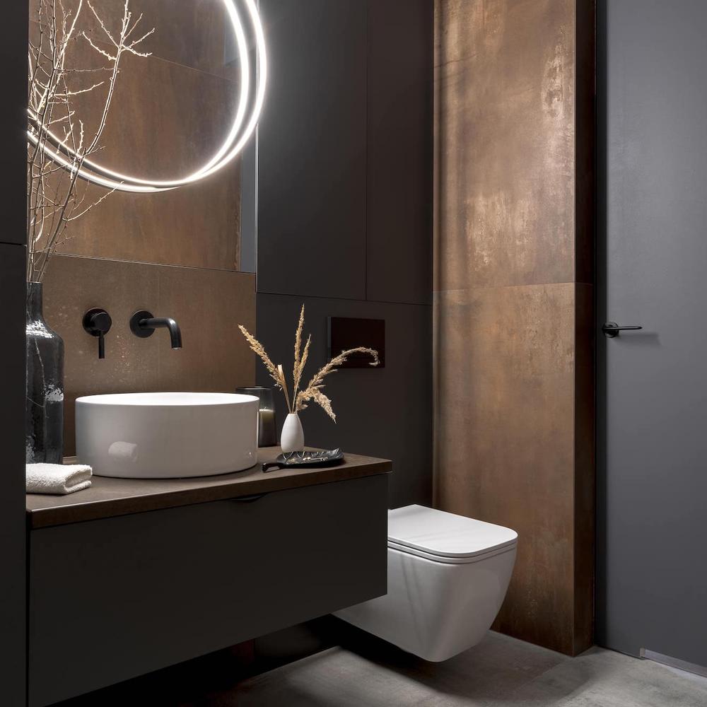 Compact dark bathroom showcasing personalized wall art and decor.
