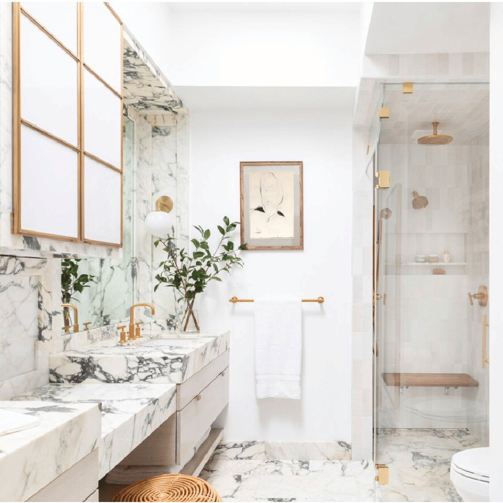 Baño pequeño de lujo con detalles elegantes, mármol y acentos dorados,