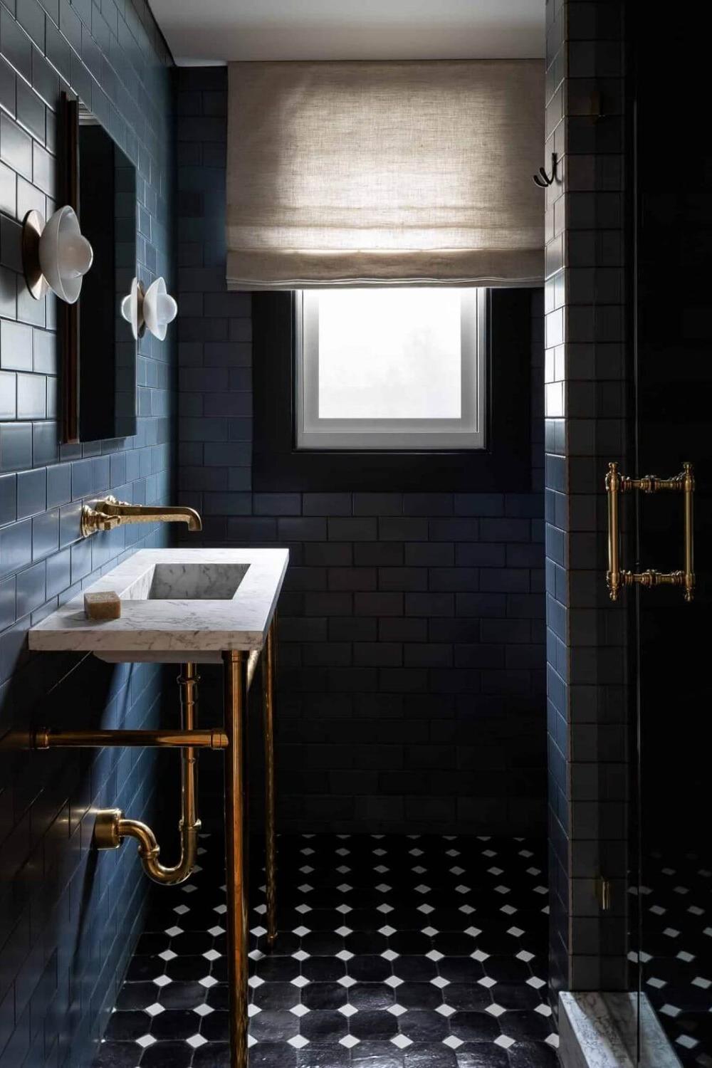 Baño pequeño que combina azul oscuro y acentos de oro