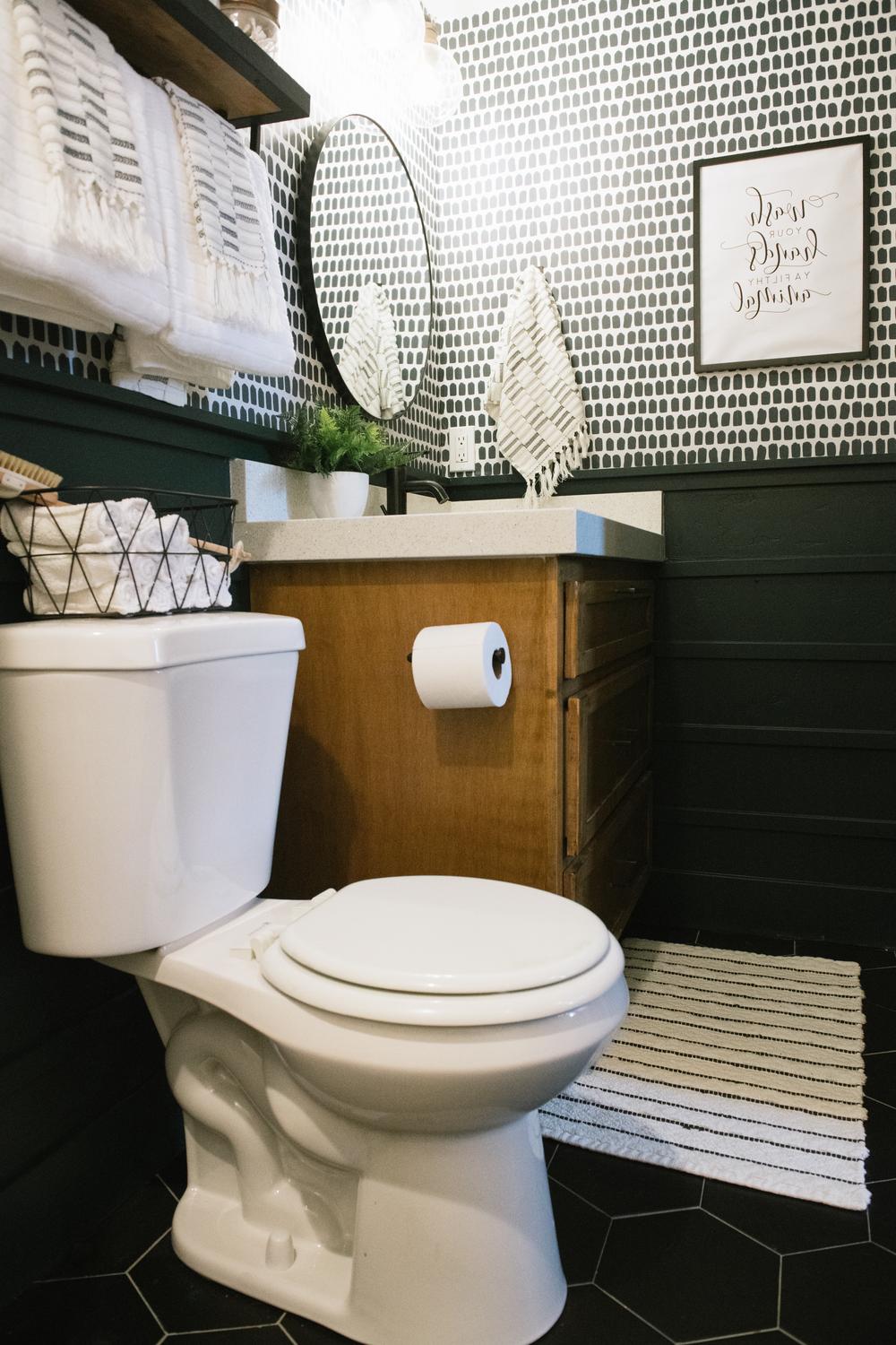 Baño pequeño con azulejos blancos y detalles orgánicos