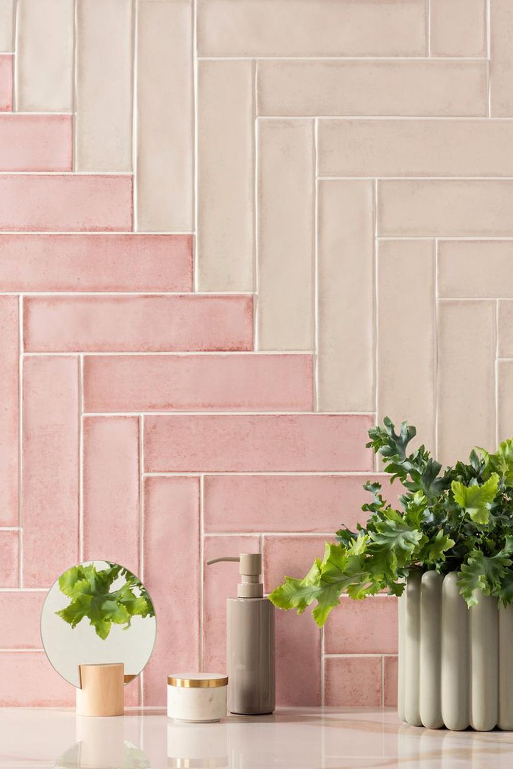 A bathroom with pink and cream herringbone patterned tiles creating a dynamic atmosphere.