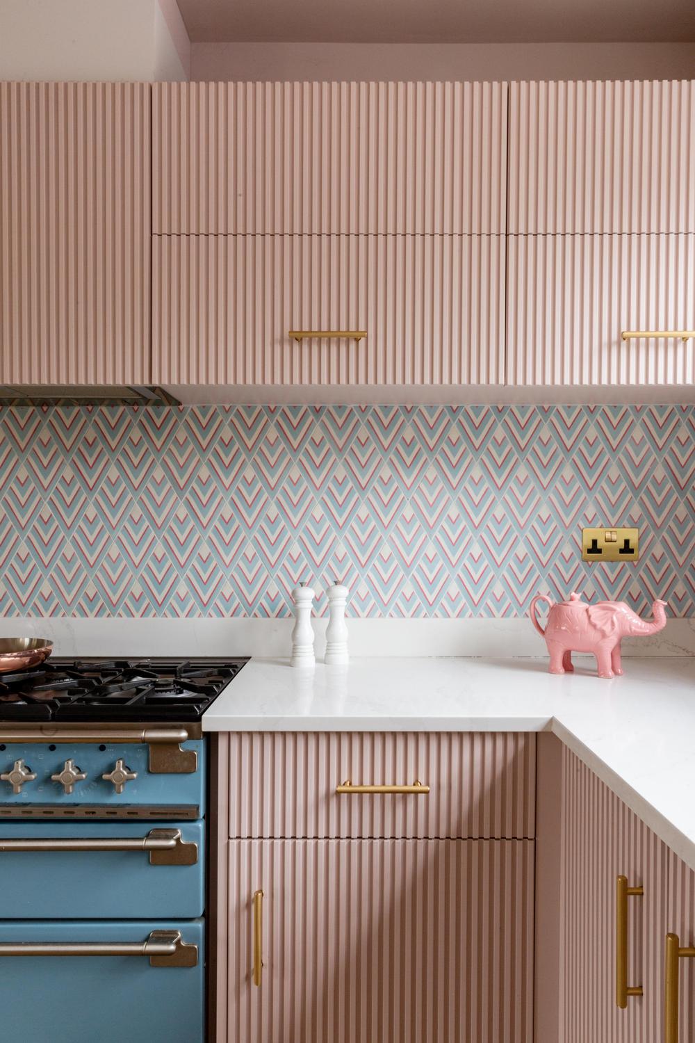 A stylish kitchen adorned with contemporary pastel cabinetry, playful decor, and cheerful floral accents.
