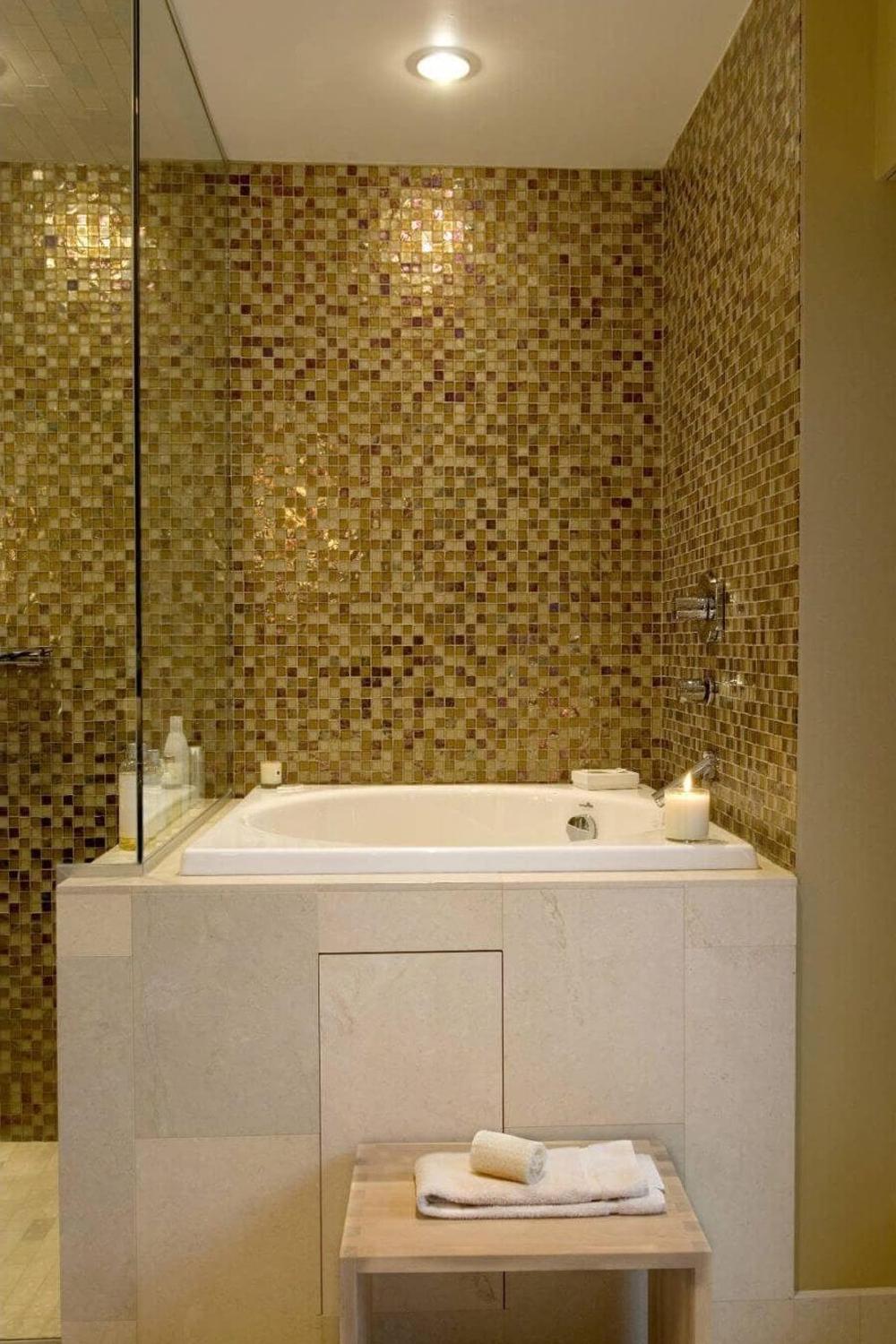 Baño lujoso con azulejos mosaicos en tonos dorados y marrones