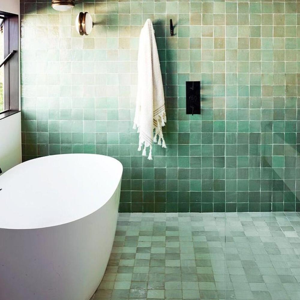 Baño modernista con azulejos verdes que aportan frescura