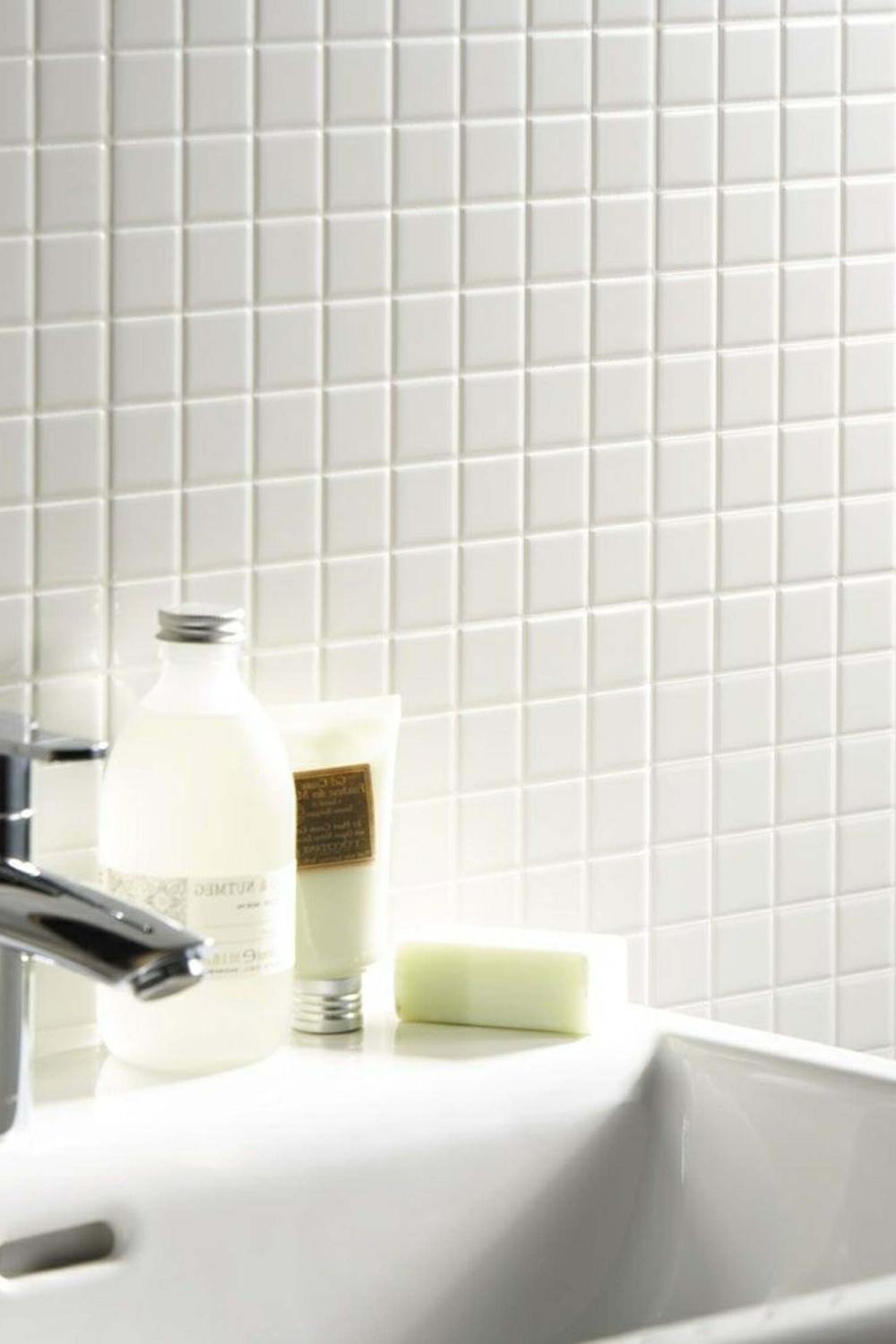 Baño elegante con azulejos blancos y accesorios minimalistas