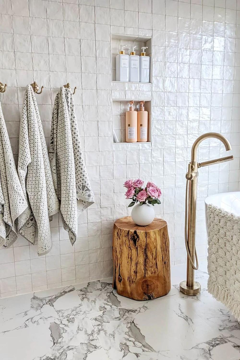Baño contemporáneo con azulejos efecto mármol y decoración natural