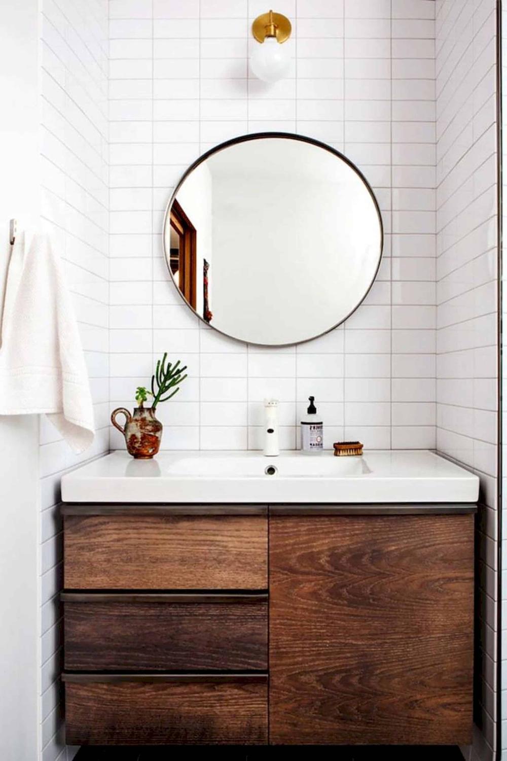 A modern bathroom with clean white subway tiles and a dark wooden vanity.