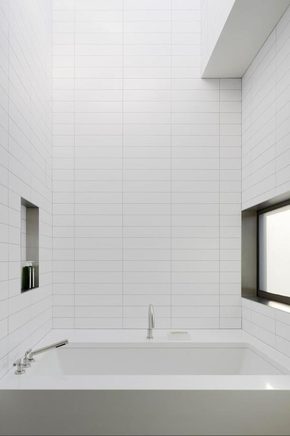 A minimalist bathroom showcasing white subway tiles and modern geometric designs.