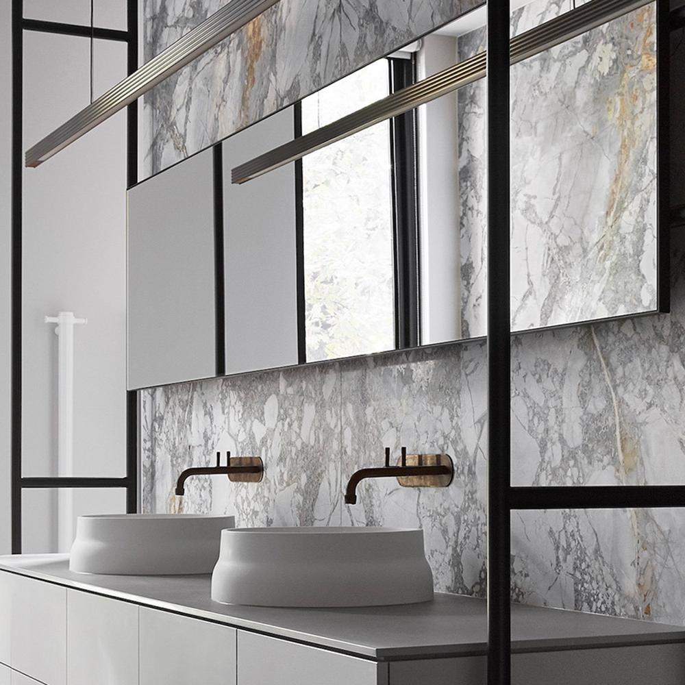 Chic modern bathroom featuring large veined marble slabs, contemporary vanity, and luxurious round vessel sinks.