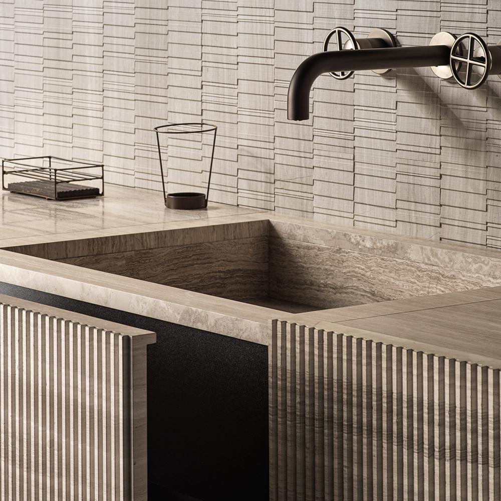 Experimental bathroom with patterned stone counter, ribbed cabinetry, and sleek matte black faucet.