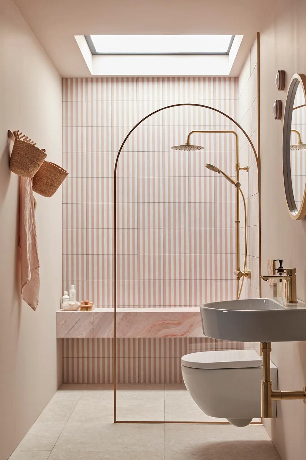 Baño minimalista con azulejos de rayas rosas y blancos