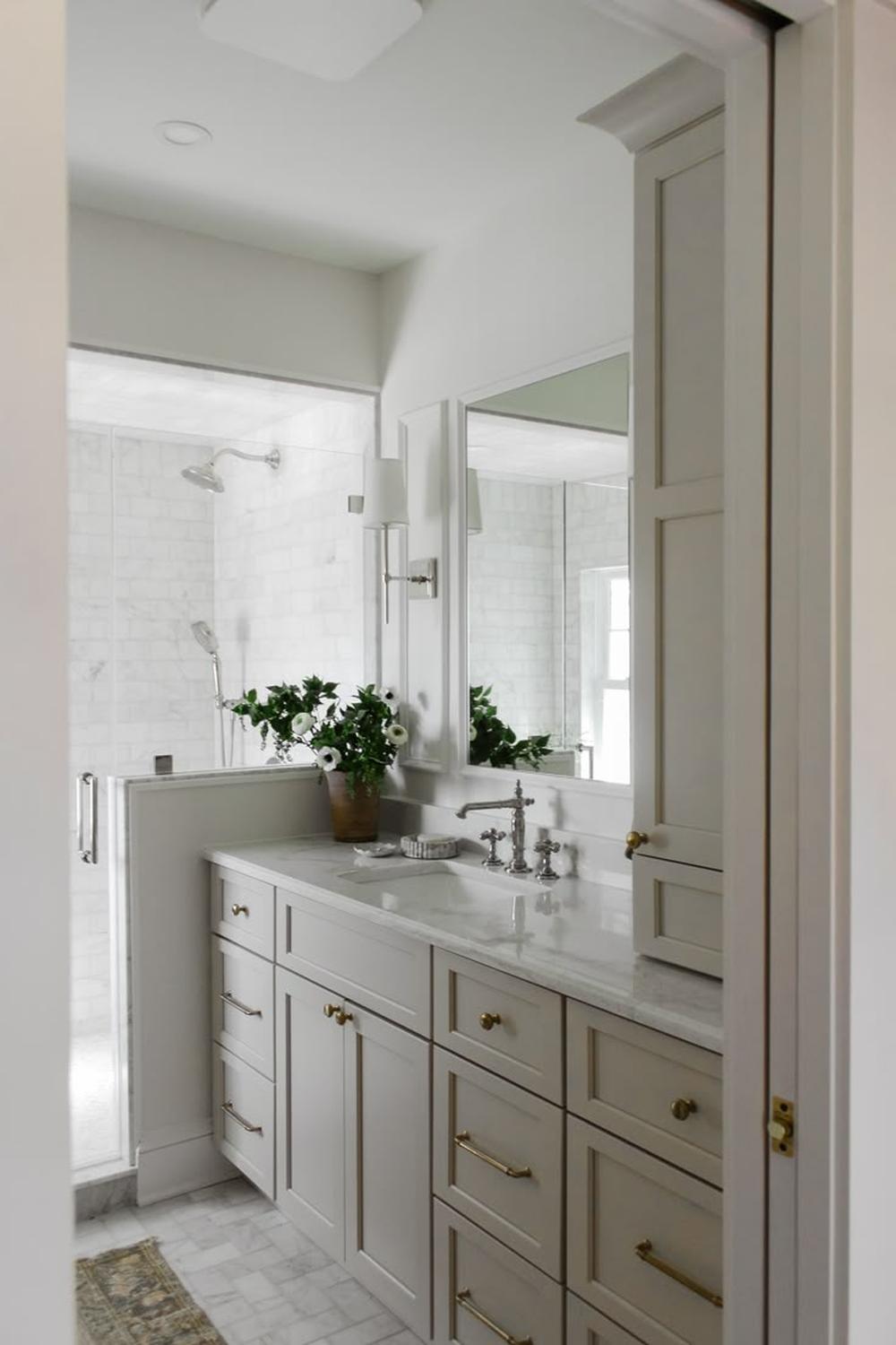 Elegante mueble de baño taupe con mármol claro.